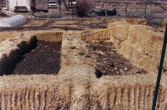 March 1989 Construction of strawbale walled garden for wind protection and water retention, plus a cloche in the upper left of photo.